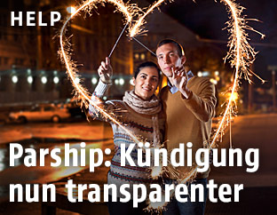 Ein Päärchen steht in der Mitte eines mit Sternspritzern erzeugten Herzens