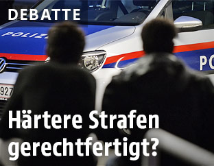 Asylwerber vor einem Polizeiwagen