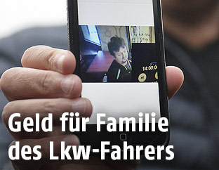 Ein Angeh&ouml;riger des polnischen Lkw-Fahrers zeigt ein Bild von ihm auf seinem Mobiltelefon