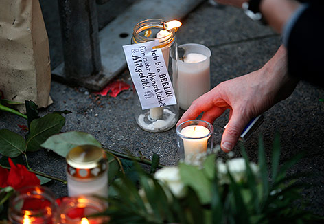 © Reuters/Fabrizio Bensch Trauernde legen Kerzen auf den Boden nieder