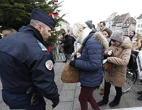 Französische Polizisten durchsuchen die Handtaschen von Weihnachtsmarktbesuchern in Straßburg