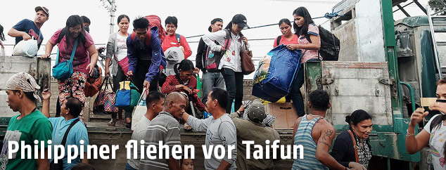 Menschen tragen Koffer auf die Ladefläche eines Transporters