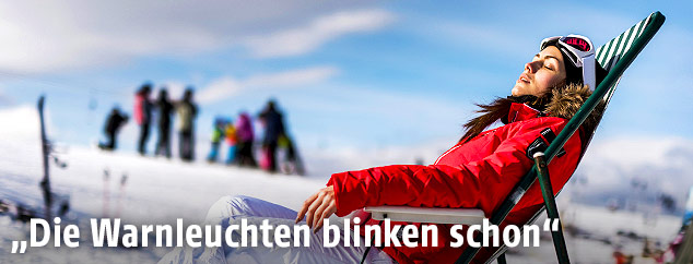 Frau sonnt sich auf einer Ski-Hütte