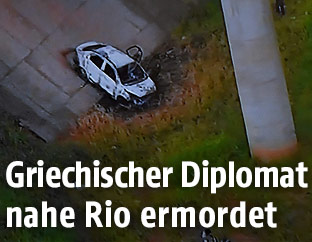 Ausgebranntes Autowrack unter einer Brücke