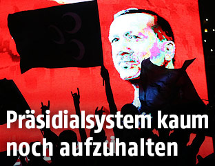 Fahnenmeer vor einem Bild Erdogans