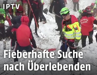 Helfer auf dem verschütteten Hotel