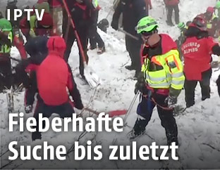 Helfer auf dem verschütteten Hotel