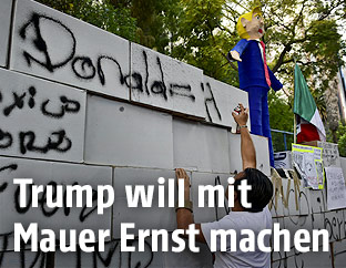 Demonstrant vor einer Mauer aus Karton