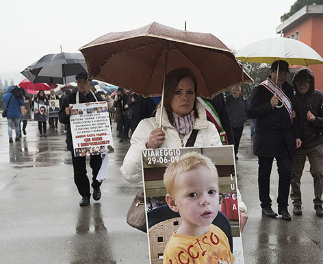 © APA/AFP/Claudio Giovannini Angehörige mit Fotos der Verstorbenen