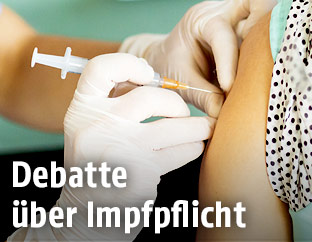Eine Ärztin verabreicht eine Schutzimpfung