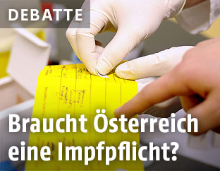Eine Amtsärztin klebt den Nachweis einer Impfung in einen Impfpass ein