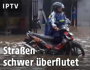 Mopedfahrer auf überschwemmter Straße