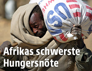 Ein Mann trägt einen Sack mit Weizenmehl auf dem Rücken