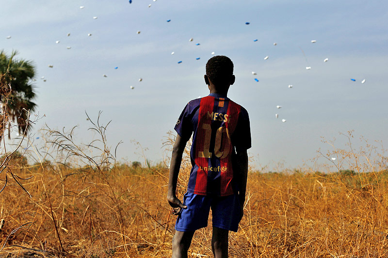 © Reuters/Siegfried Modola Ein Bub blickt auf vom Himmel fallende Hilfspakete