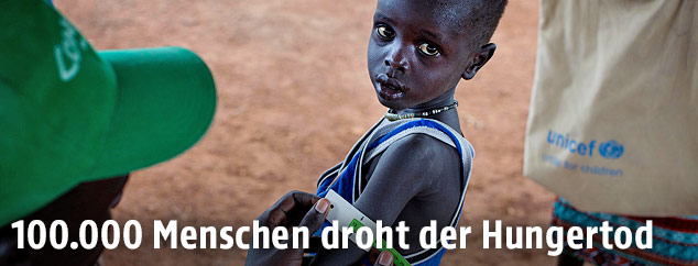 Eine Person misst den Oberarmumfang eines Buben