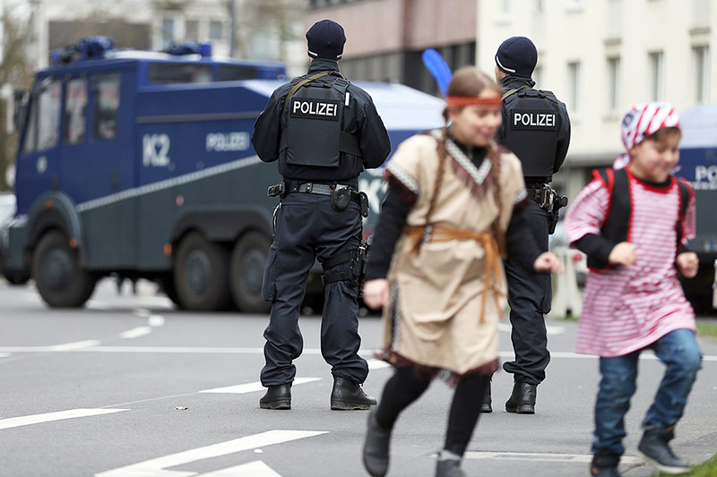 © APA/AP/dpa/Rolf Vennenbernd
Kinder in Karneval-Kostümen laufen bei Polizisten vorbei