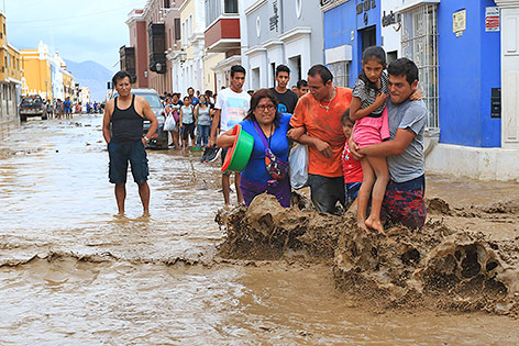 © APA/AFP/Celso Roldan Menschen auf einer überfluteten Straße