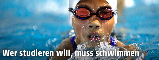 Frau schwimmt in Hallenbad