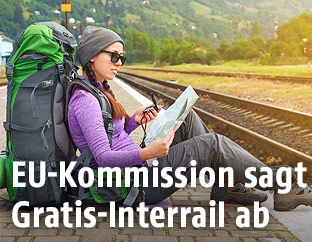 Eine Rucksacktouristin sitzt am Bahnsteig