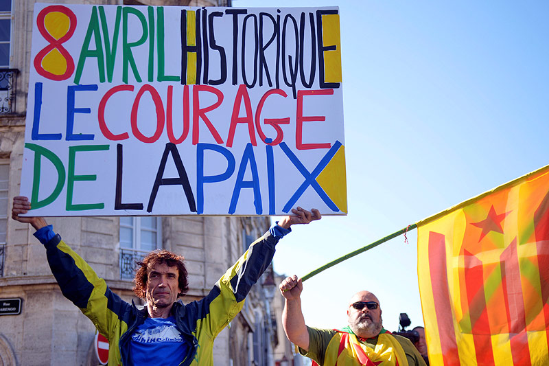 © Reuters/Vincent West Ein Mann hält ein Schild in der Höhe mit der Aufschrift "8 Avril Historique Le Courage De La Paix" (Historischer 8. April. Der Mut des Friedens)