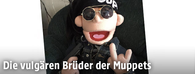 Handpuppe mit Sonnenbrille und "Stinkefinger"