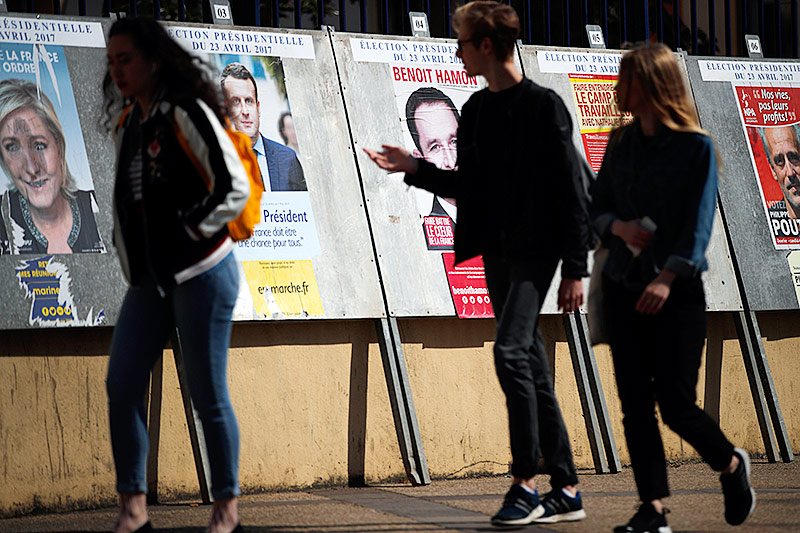 Menschen gehen an Wahlplakaten vorbei