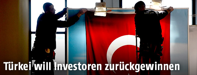 Arbeiter beim Aufhängene einer türkischen Fahne