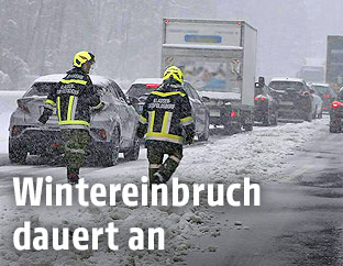 Feuerwehrmänner auf der verschneiten A21