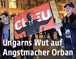 Demonstranten mit einem Plakat, auf dem Staatschef Viktor Orban den Schriftzug "CEU" zerrei&szlig;t