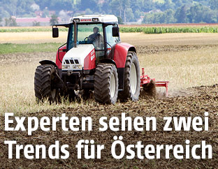 Traktor auf einem trockenen Feld bei der Ernte