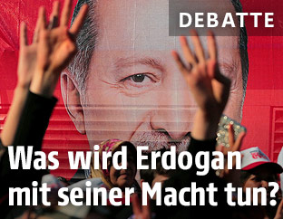 Menschen vor einem Plakat von Recep Tayyip Erdogan