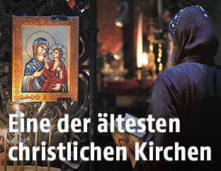 Betende Person vor einer christlichen Ikone