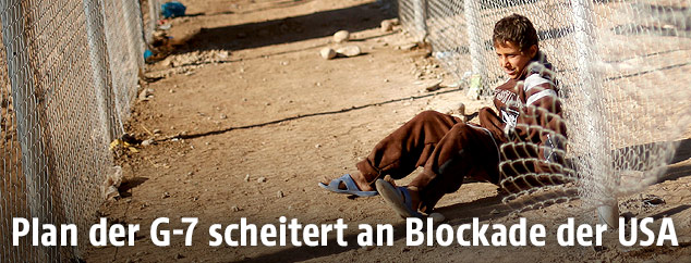 Flüchtlingskind an einem Zaun