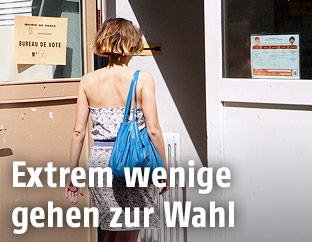 Frau betritt Wahllokal in Paris