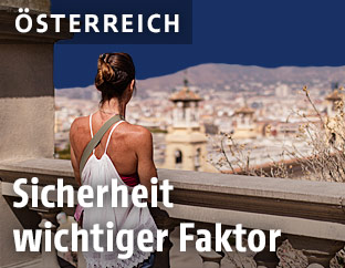 Frau blickt von einem Aussichtsplatz auf Barcelona