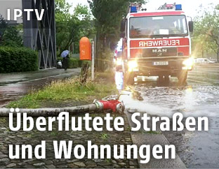 Feuerwehrauto und Wasserschlauch auf einer Straße