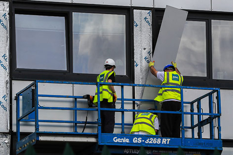 © APA/AP/Peter Byrne Arbeiter an einer Hochhausfassade