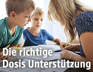 Mutter kontrolliert die Hausübungen ihrer beiden Söhne