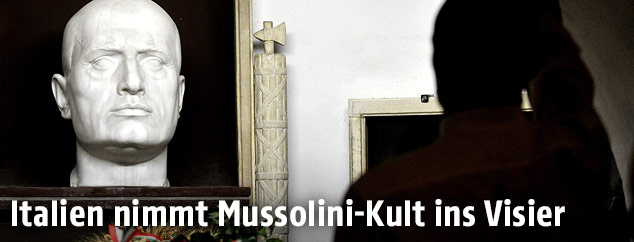 Ein Mann vor einer Mussolini-Büste