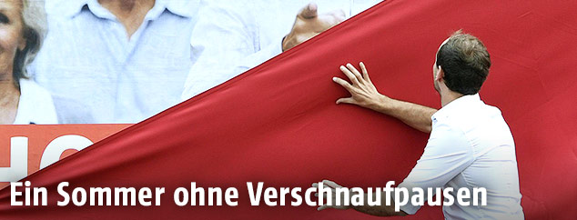 Mann enthüllt ein Wahlplakat