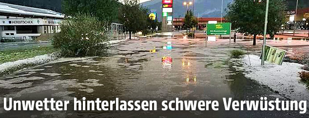 &Uuml;berschwemmte und mit Hagel bedeckte Stra&szlig;e