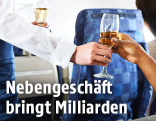 Flugbegleiterin bringt einem Gast ein Glas Sekt