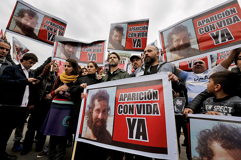 © AP/Victor R. Caivano Verwandte von Aktivisten mit Santiago Maldonado halten Schilder mit dem Aufruf "Erscheine jetzt lebend"