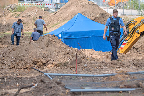 © APA/AFP/Boris Roessler Ein Polizist vor einem Zelt an der Ausgrabungsstelle der Bombe