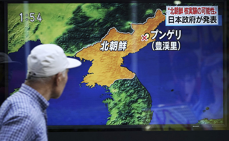 Fußgänger in Tokio passiert einen Fernseher in einer Auslage, mit dem Bericht über den Atomtest