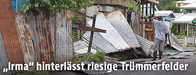 Ein Mann steht vor seinem zerstörten Haus