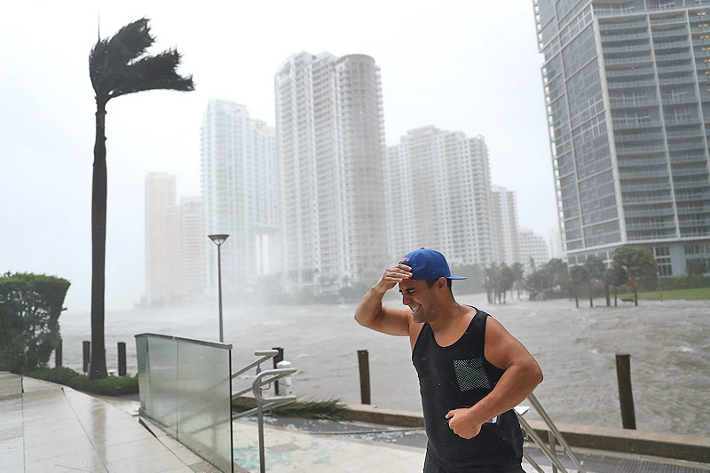 © APA/AFP/Getty Images/Joe Raedle Ein Mann kämpft am über die Ufer getretenen Miami River in Miami gegen den Wind an