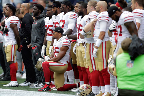 NFL-Spieler Eric Reid kniet während der Nationalhymne