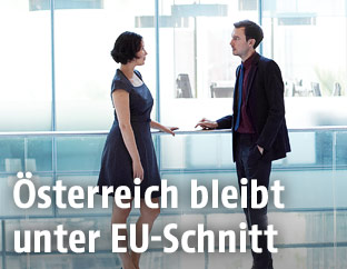 Mann und Frau sprechen in einem Bürohaus miteinander