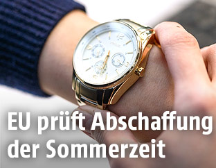 Frau sieht auf ihre Uhr